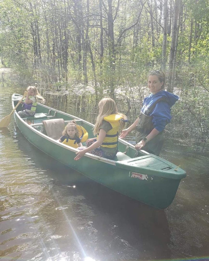 The Thompson family in the canoe on Manitoba flood waters