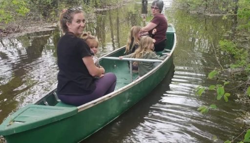 Brian Thompson's family sits aboard a canoe in Manitoba flood waters
