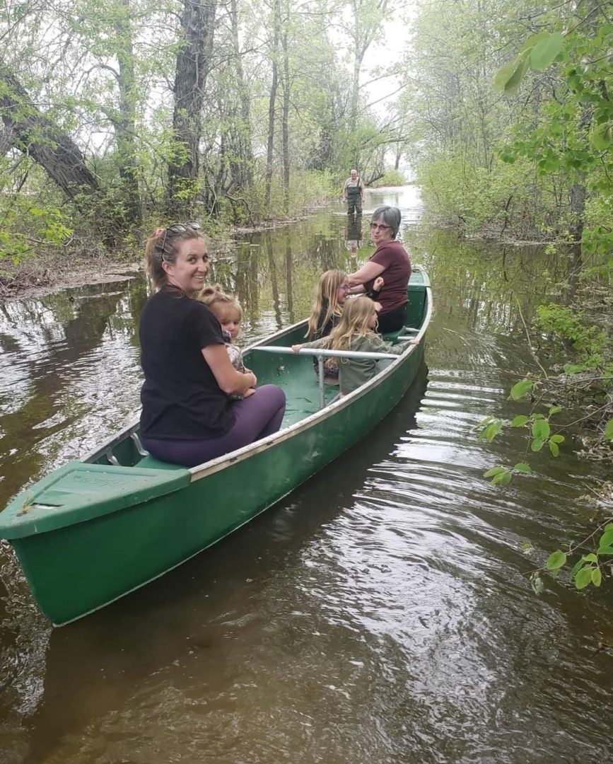 Brian Thompson's family sits aboard a canoe in Manitoba flood waters