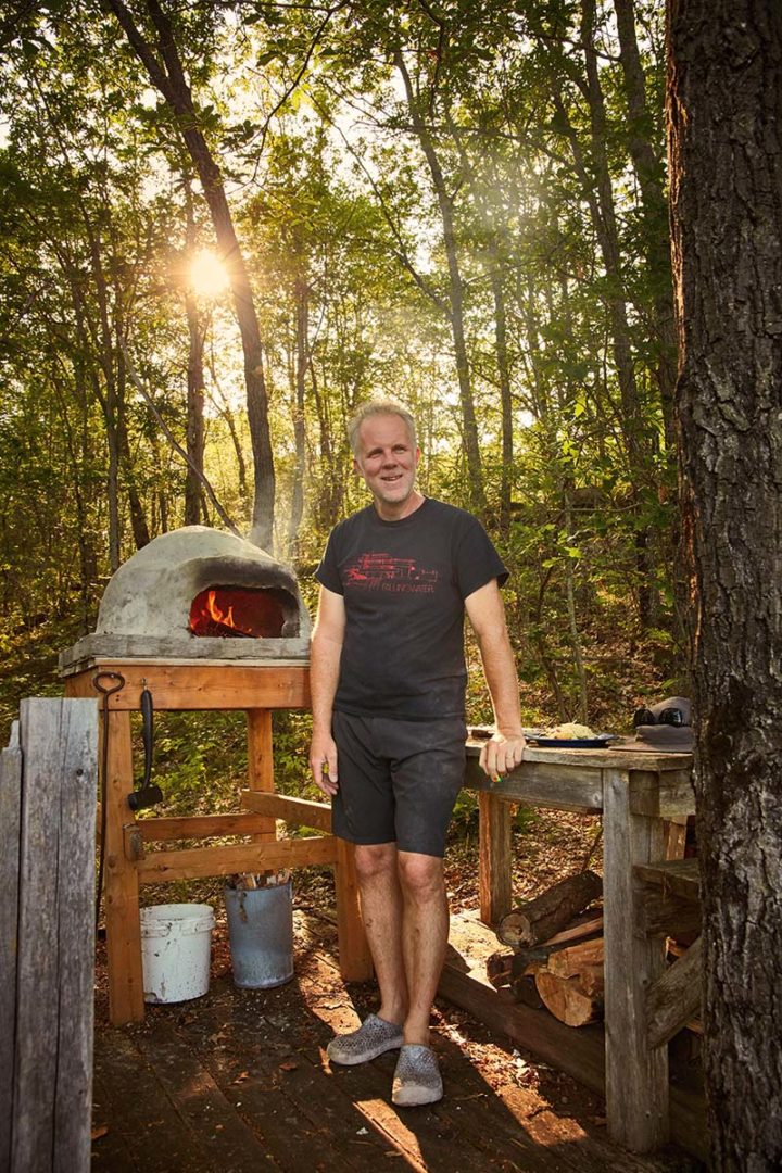 Andrew stands in front of his pizza oven.