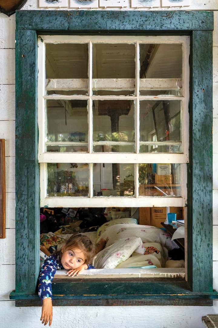 Christina's great granddaughter sits in a window frame.