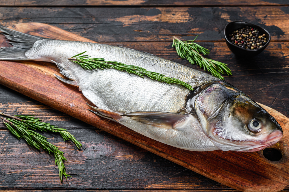 silver carp on a chopping board with herbs asian carp