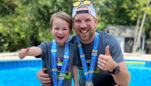 Adam Holman and his son show off their triathlon medals.