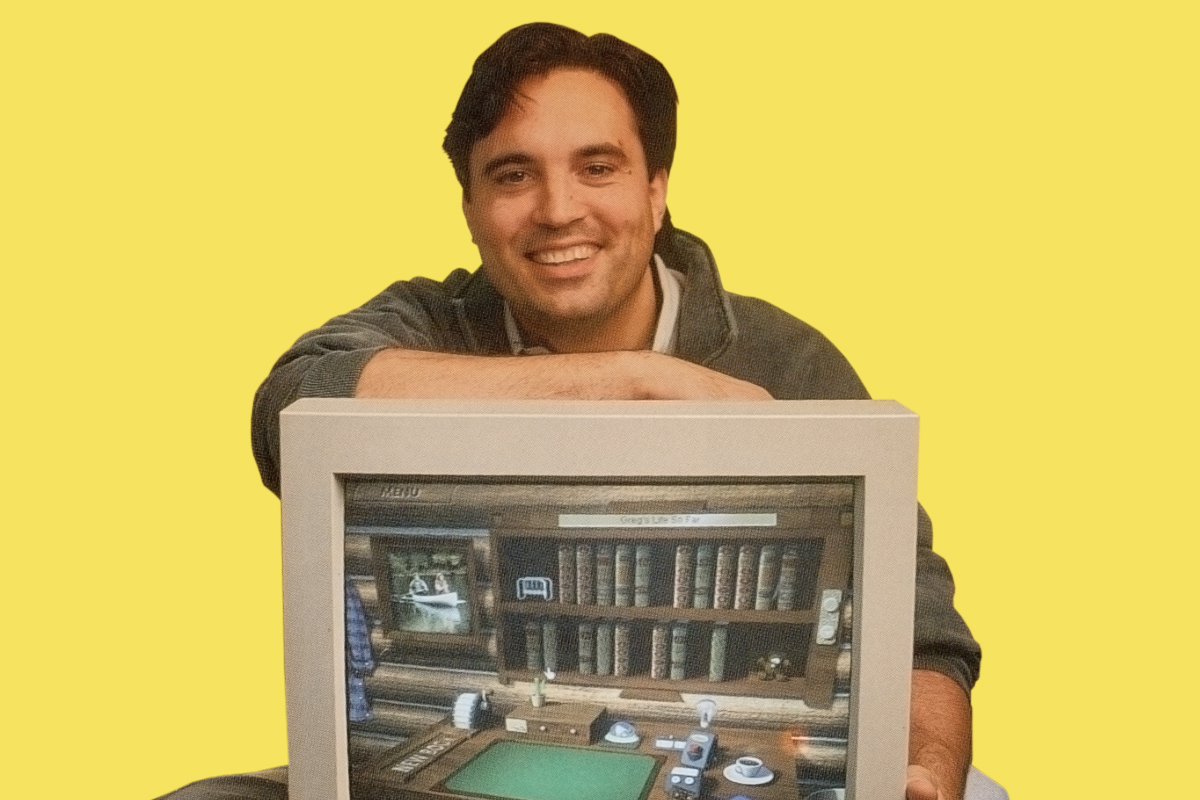 a man sits with a large desktop compute that shows the digital logbook he designed for his cottage