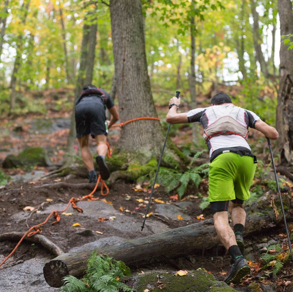 Two people climb a steep trail.