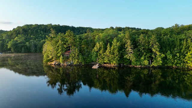 a shot of the cottages from the water with the blue sky in the background