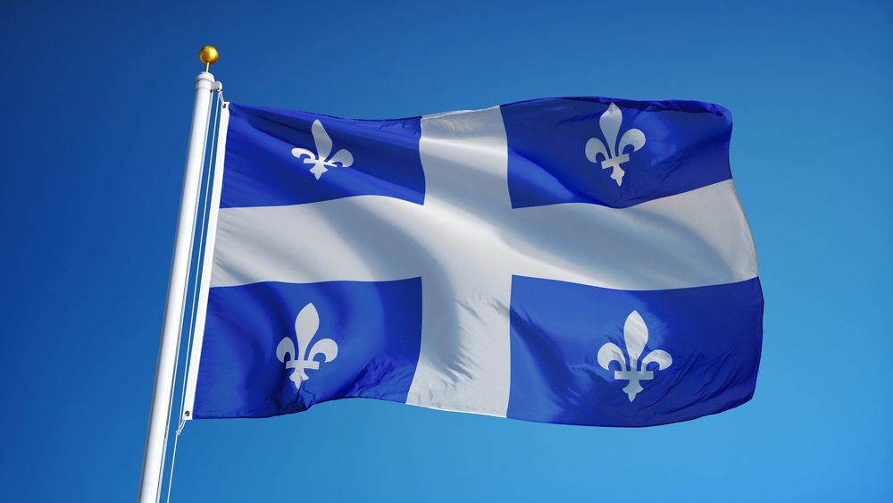 A Quebec flag waving against the blue sky