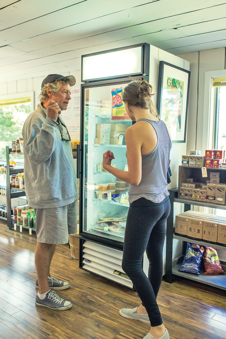 An employee of The Hive helps a man select an item from the café's fridge