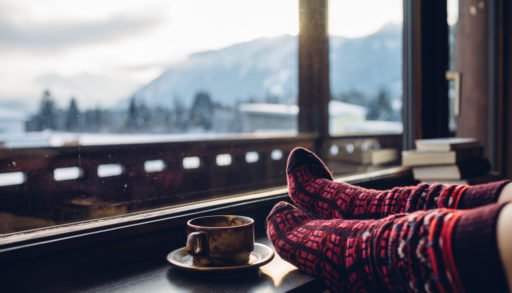 A pair of feet in wool socks in front of a mountain view