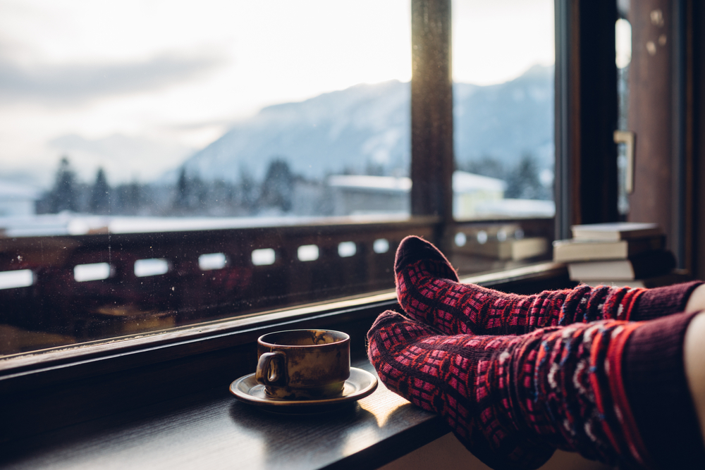 A pair of feet in wool socks in front of a mountain view