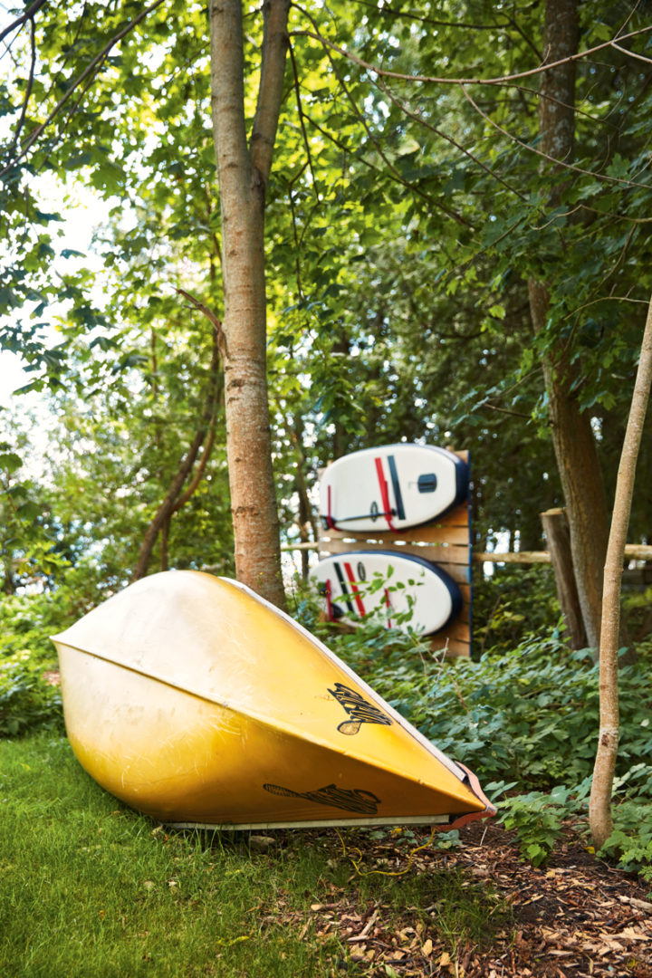 a canoe and paddleboard rack outside the cottage