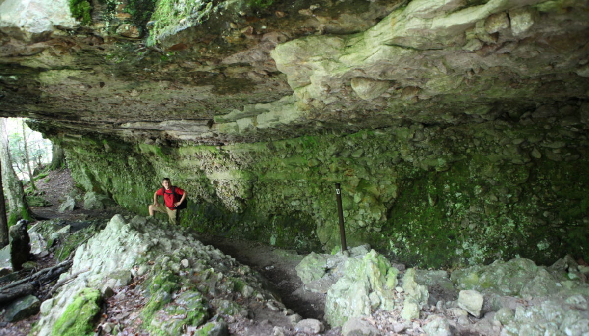 a man stands in the natural caves at Charleston Lake Provincial Park