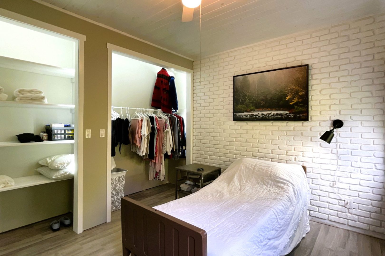 a bedroom with a single bed and open closets