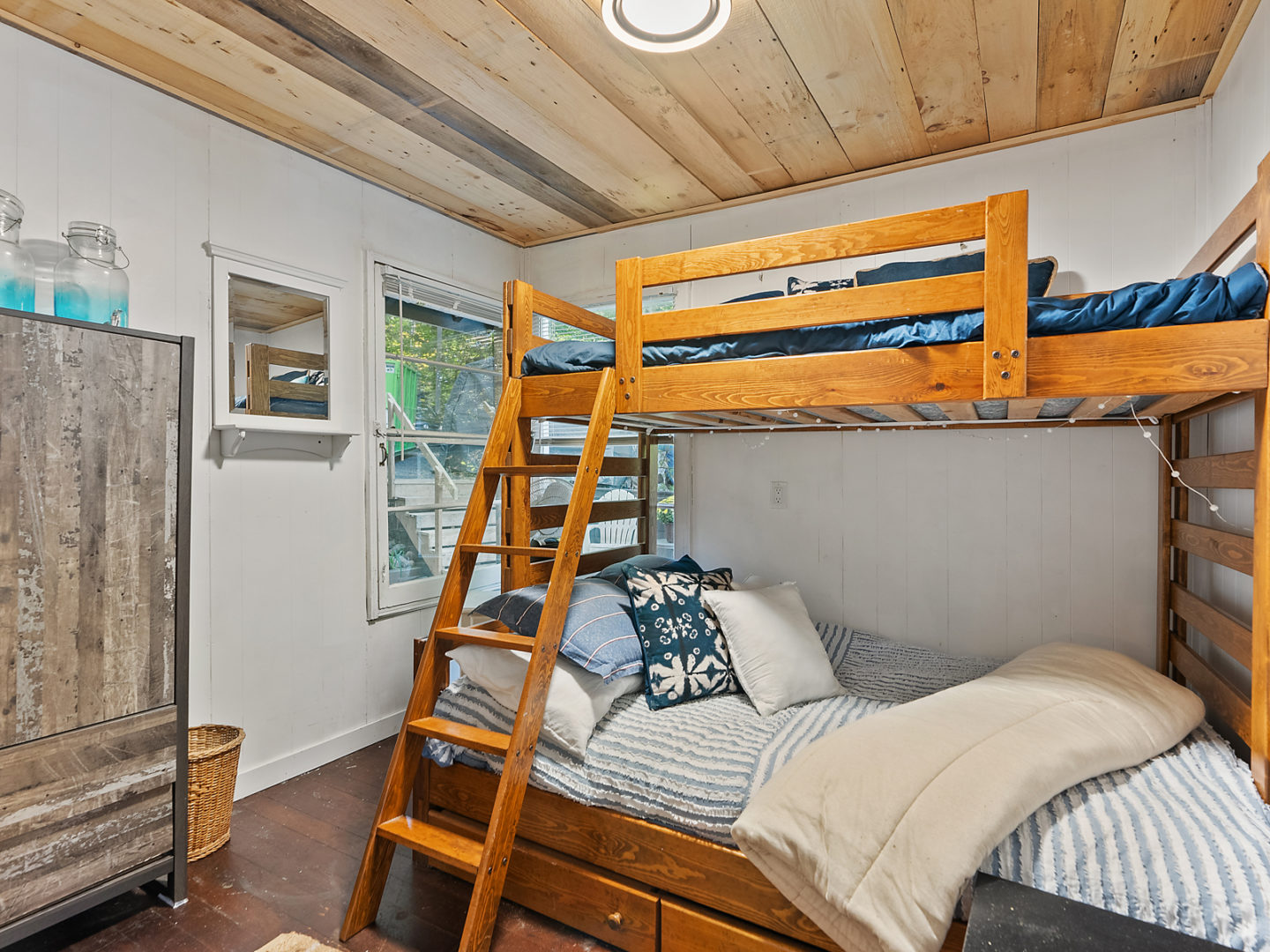 A small bedroom with a set of wooden bunkbeds.
