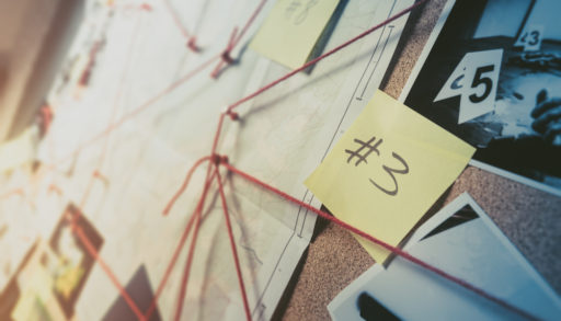 A detective board covered with notes and crime scene images