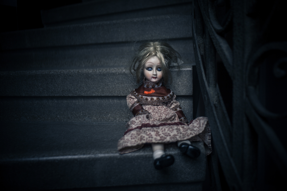 An old doll sitting on a set of stairs
