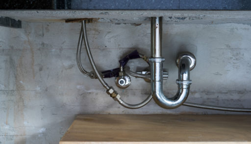 Stainless steel pipes against a concrete wall