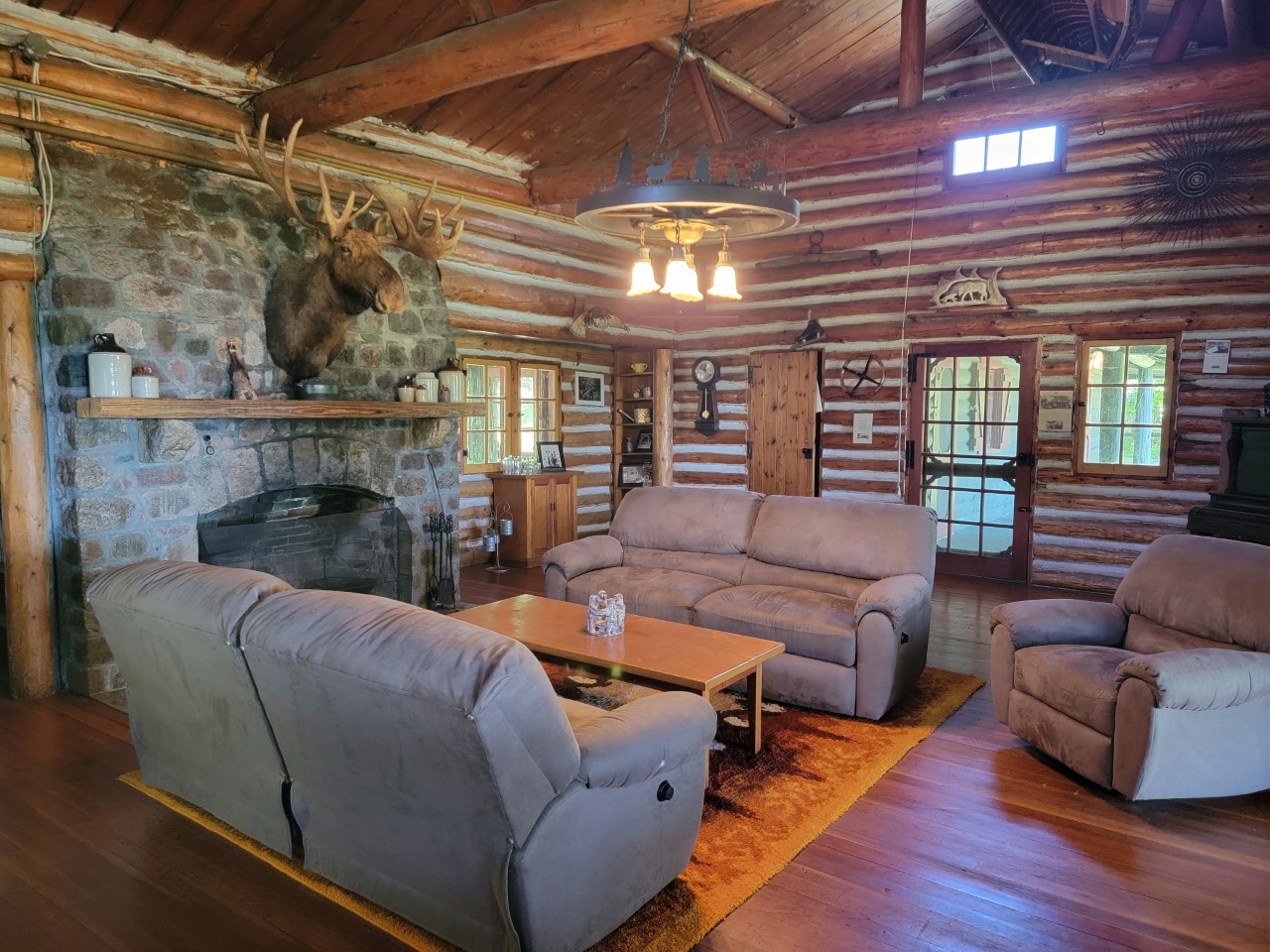 A large room with couches, a fireplace, and wooden floors.