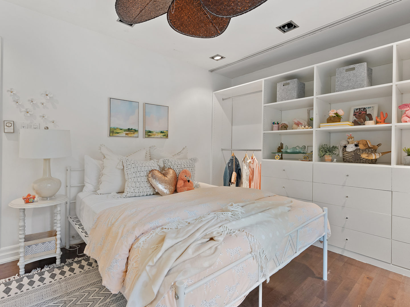 A bright bedroom with a large bed and white decor.