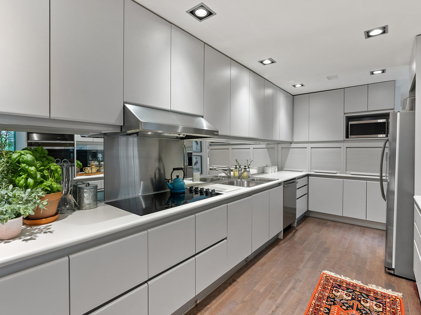 A moderately-sized kitchen with lots of drawers and cupboard space and a sleek stovetop.