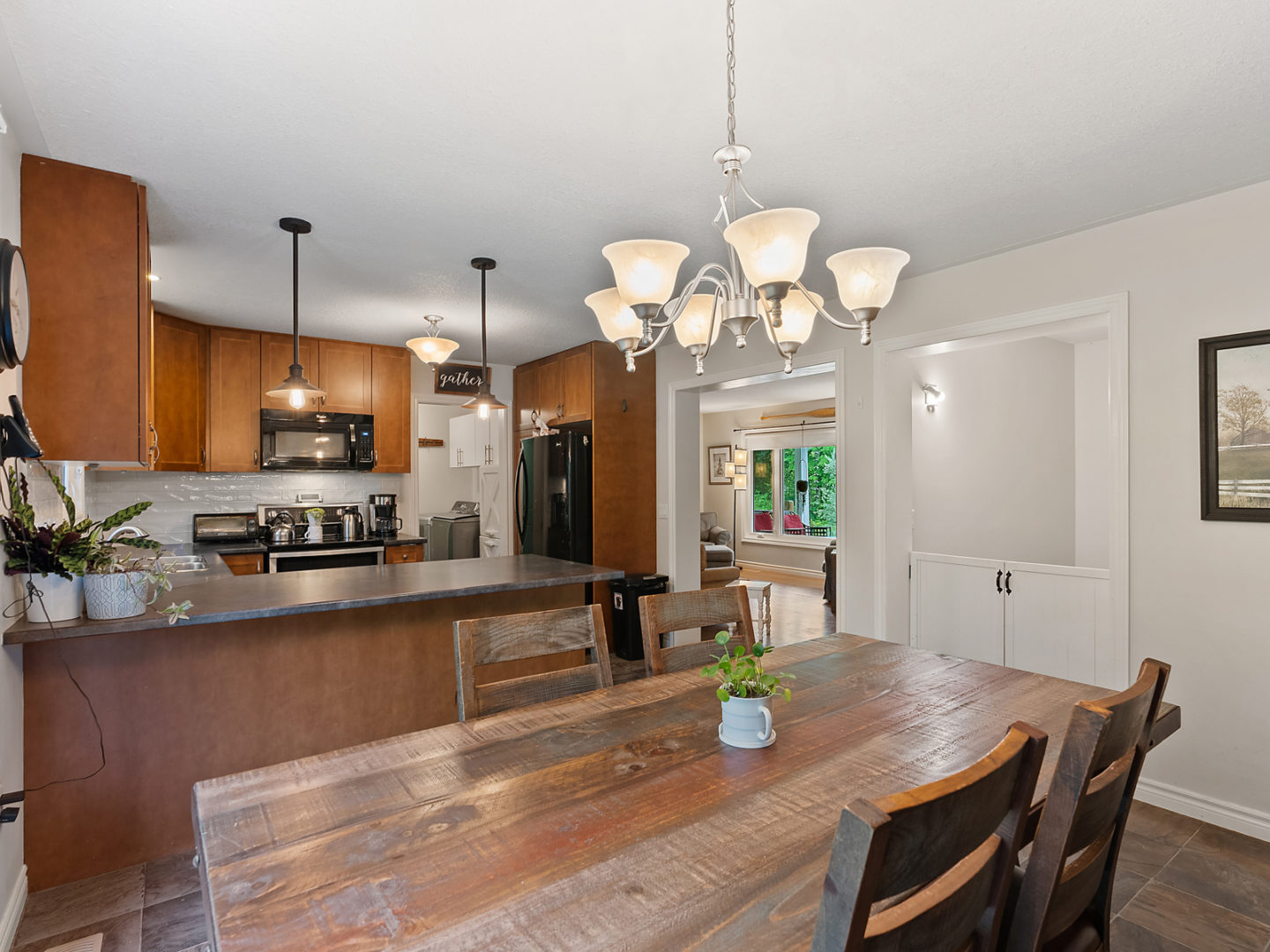 An open kitchen area with a dining room table, large countertops and updated appliances.