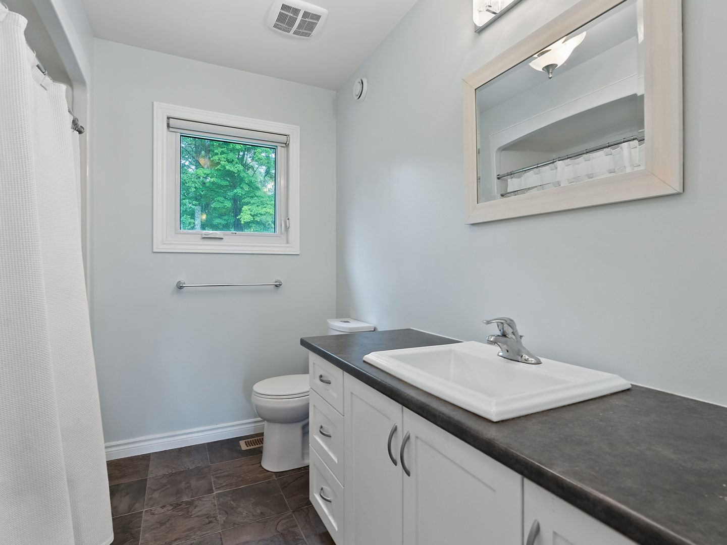 A simple bathroom with a toilet, a sink, and a bathtub.