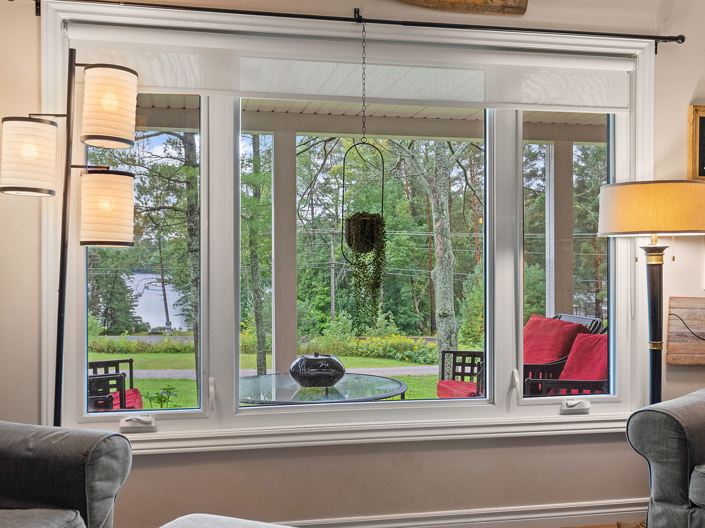A large front window looking out to a rural area with trees.