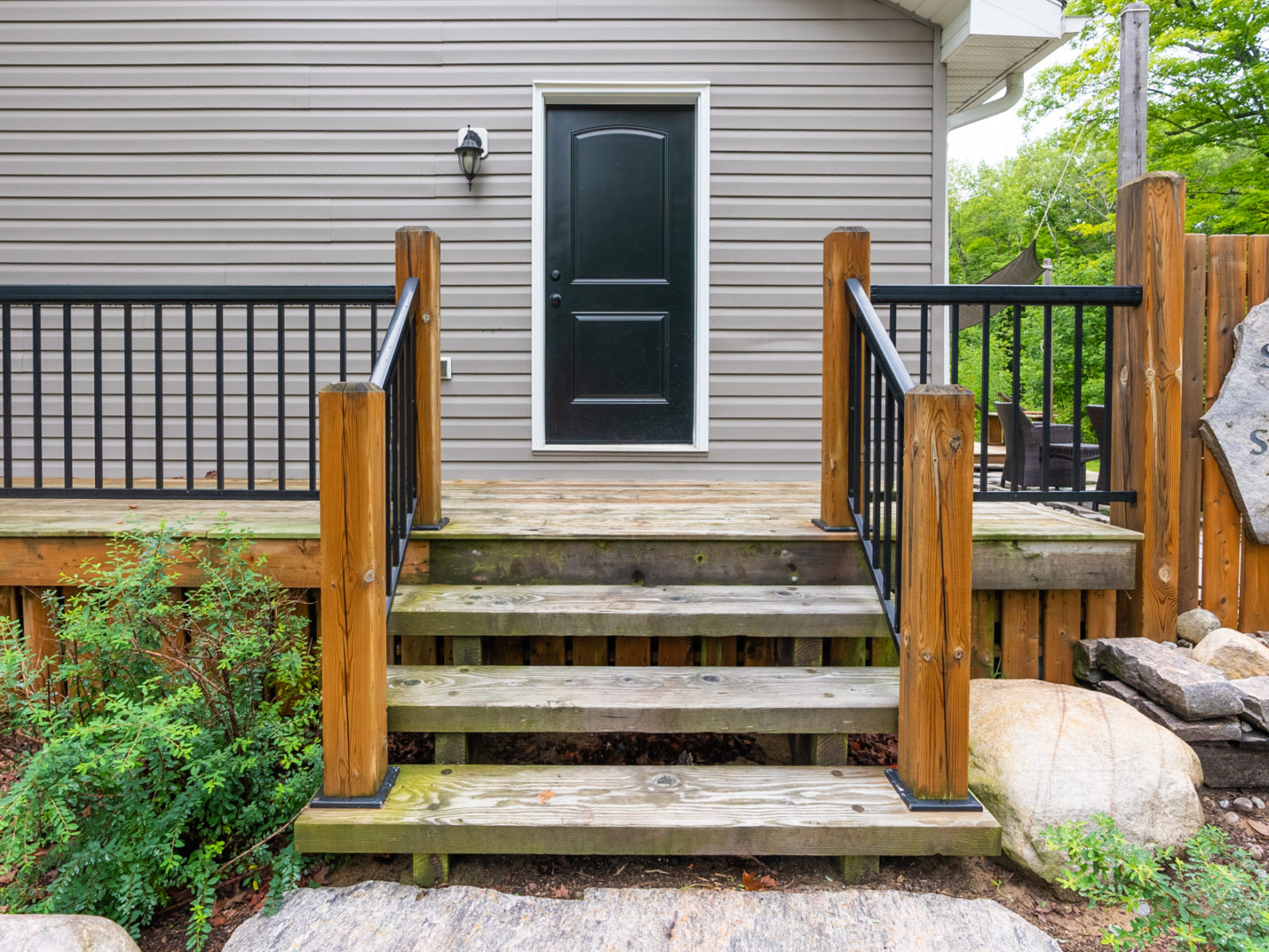 Wooden stairs leading up to the side entrance of a small cottage.
