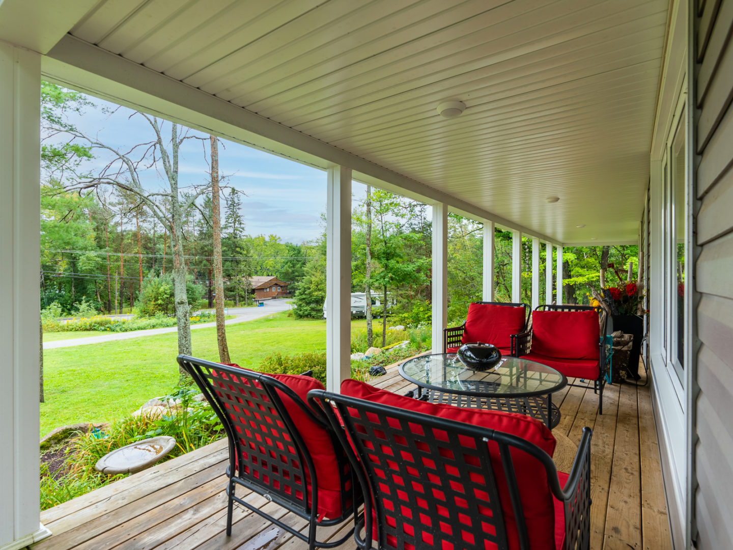 A large front porch area with bright red patio chairs.
