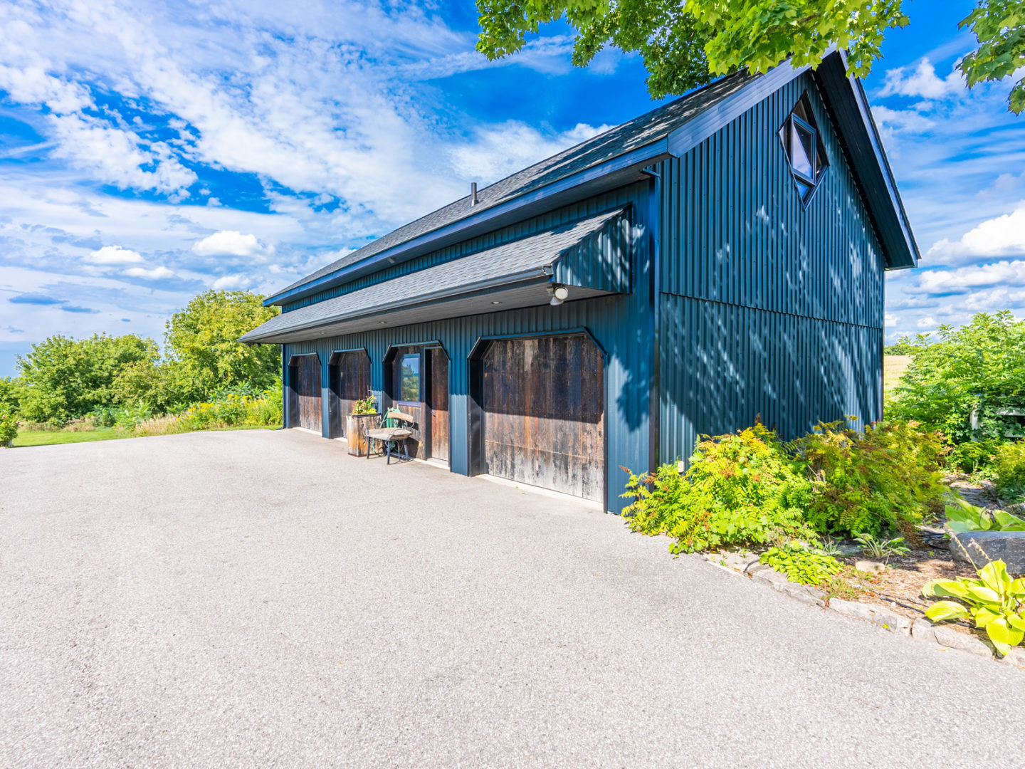 A small building with four garage doors in the front and a sloping roof.
