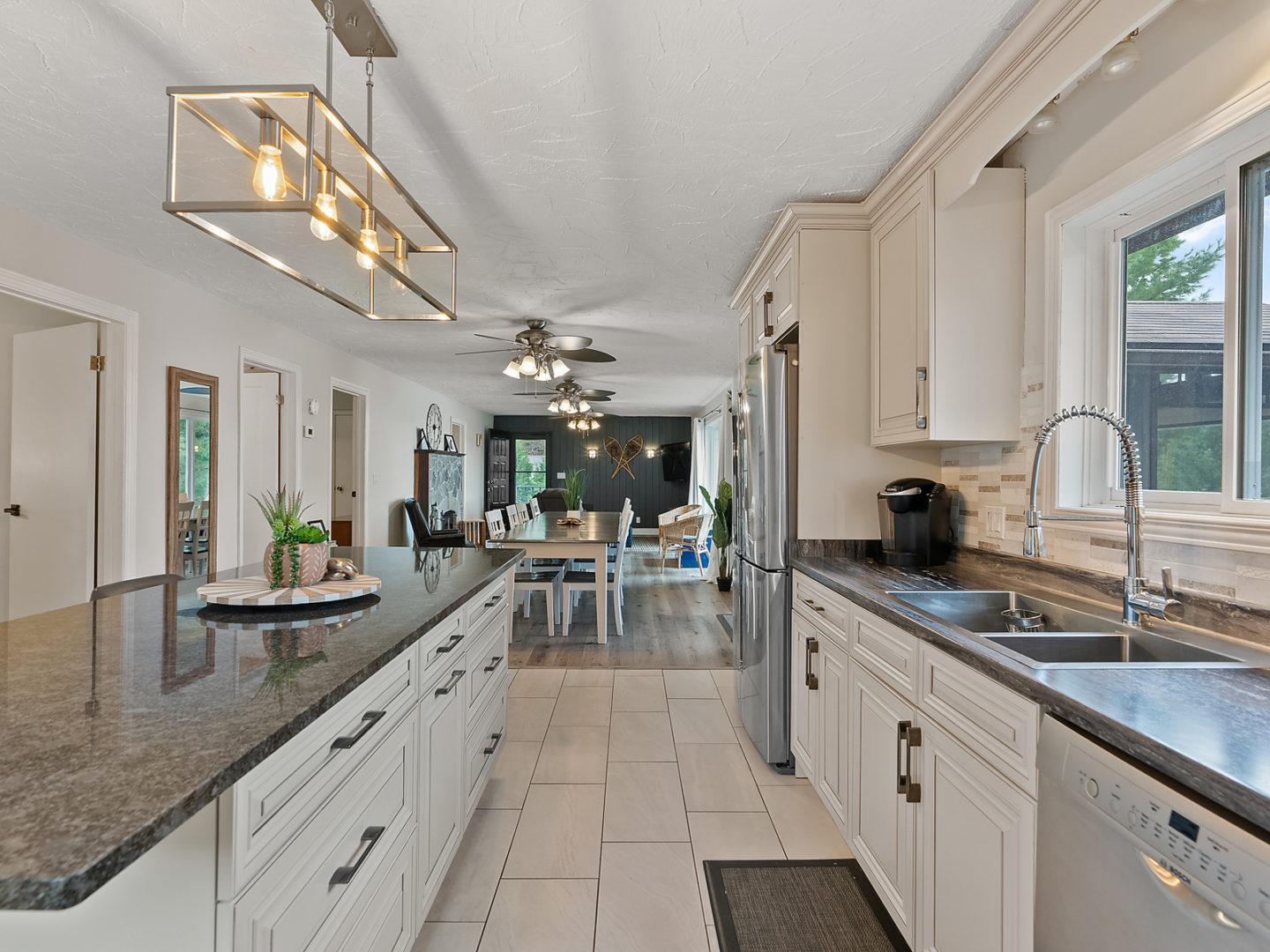 A large kitchen area that flows into an open-concept style living and dining room.