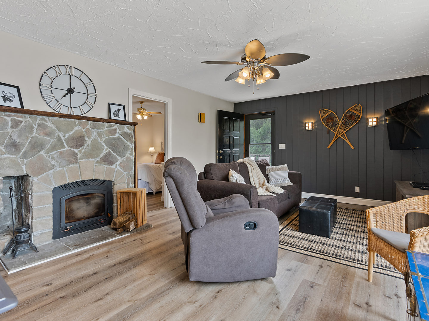 A living room with a wood-burning fireplace, a reclining chair, and a couch.