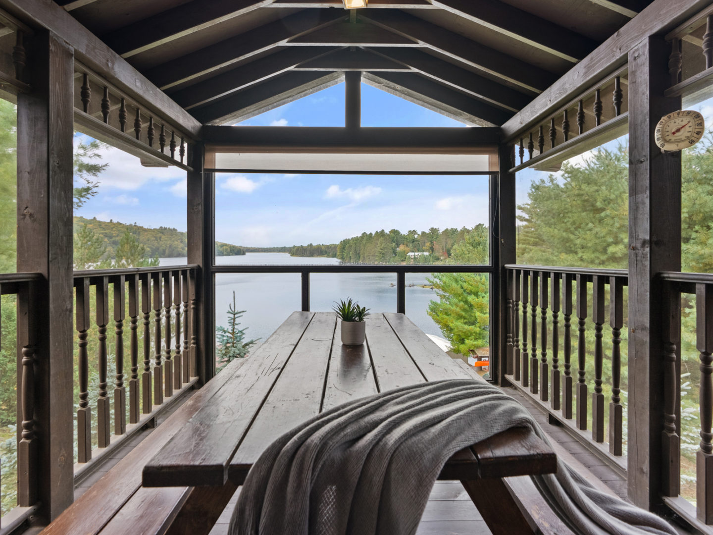 A spacious screened-in patio, complete with a picnic table and lake views.