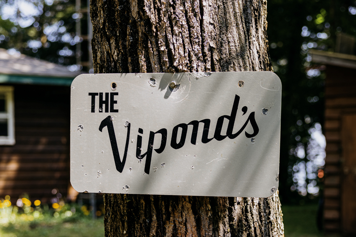A sign that reads The Viponds attached to a tree trunk