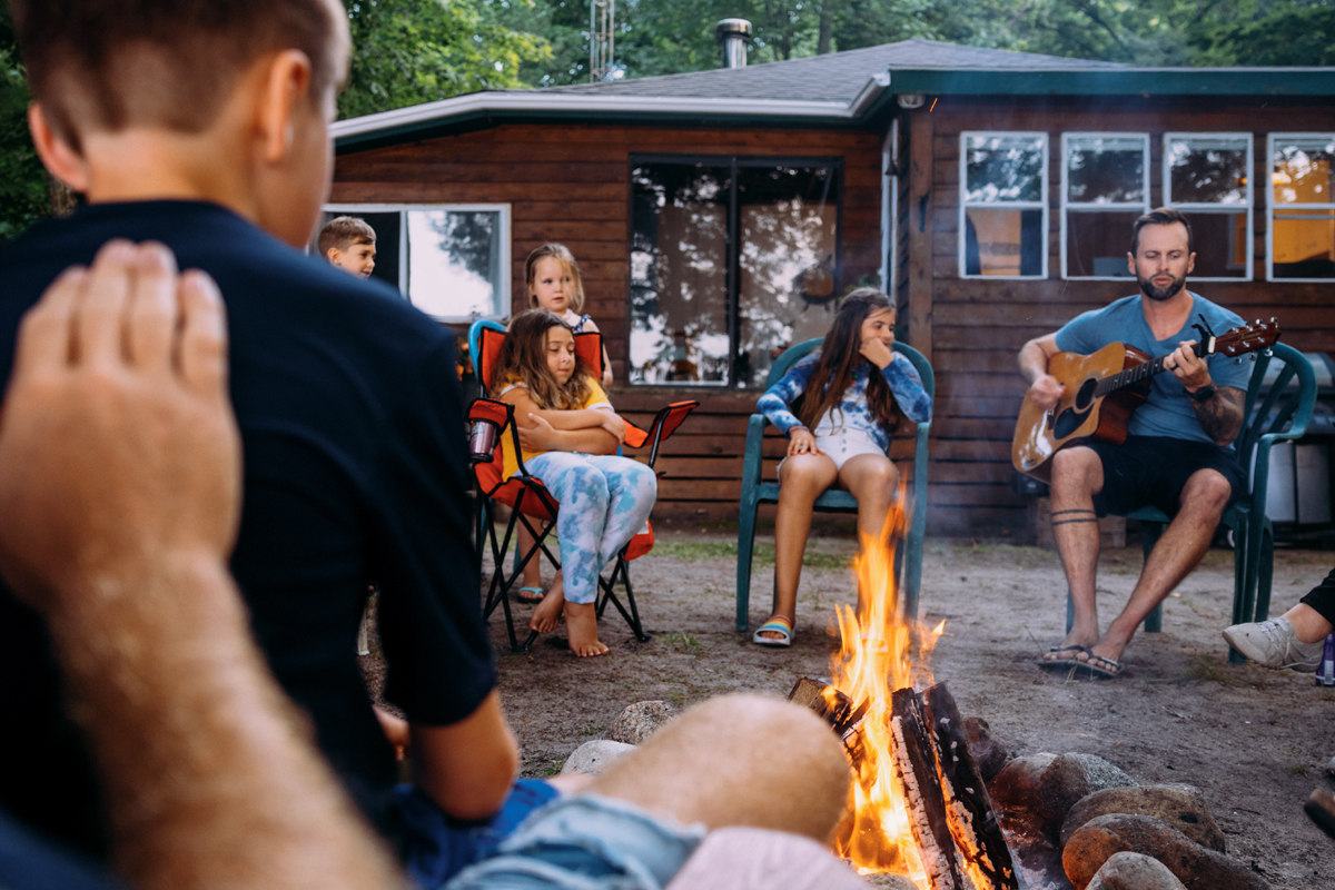 The Viponds and guests sitting around a campfire at dusk