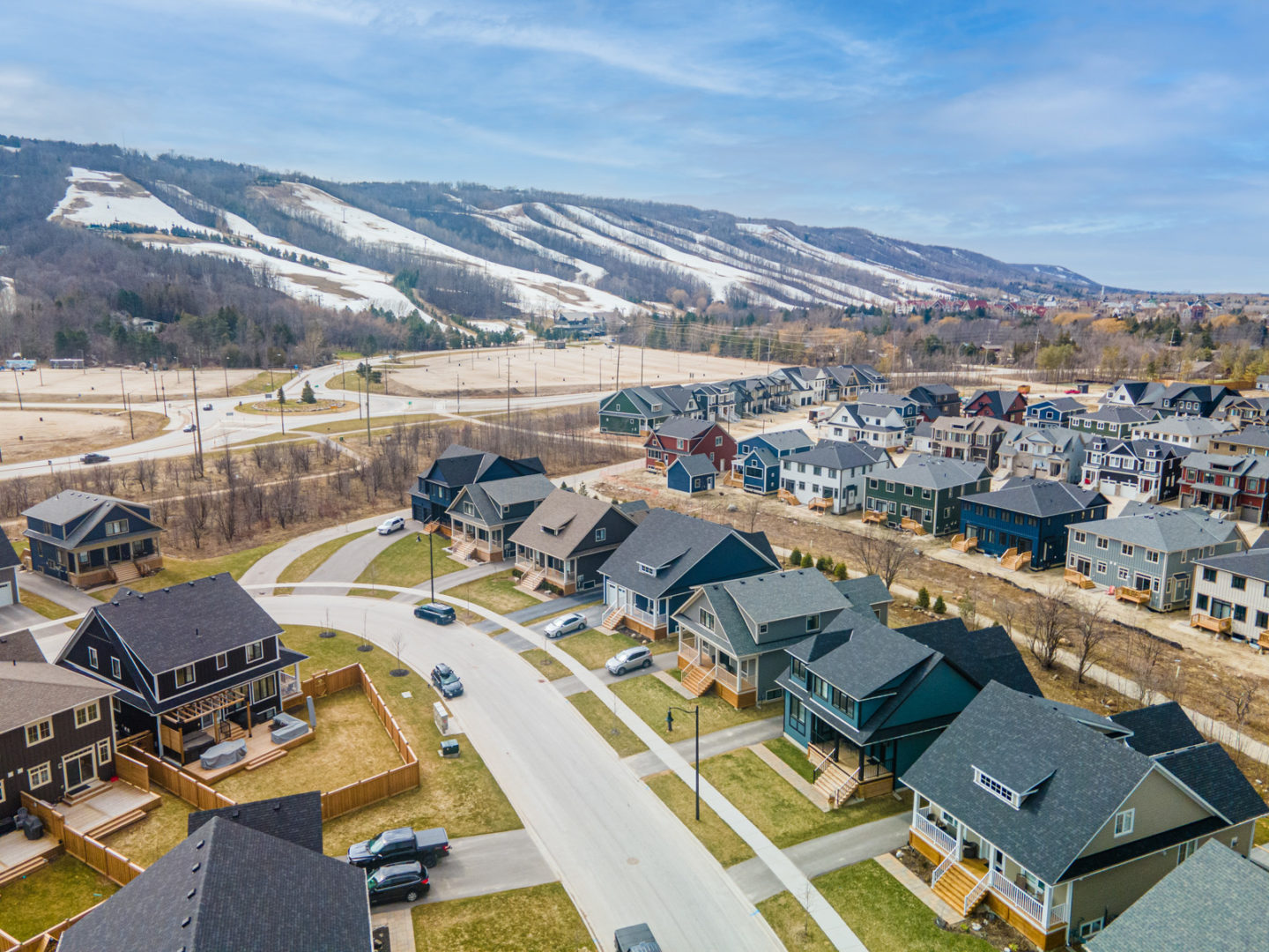 Overhead view of a small residential street with new homes and a mountain in the background.