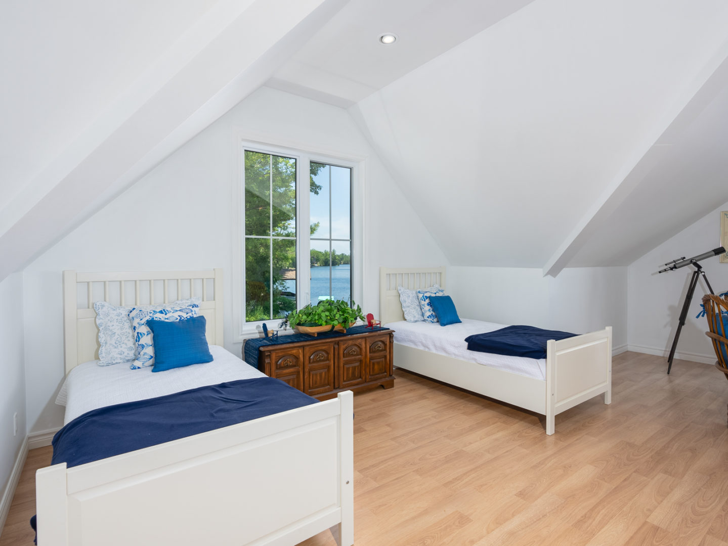 A bright, open area with two single beds on either side of a window.