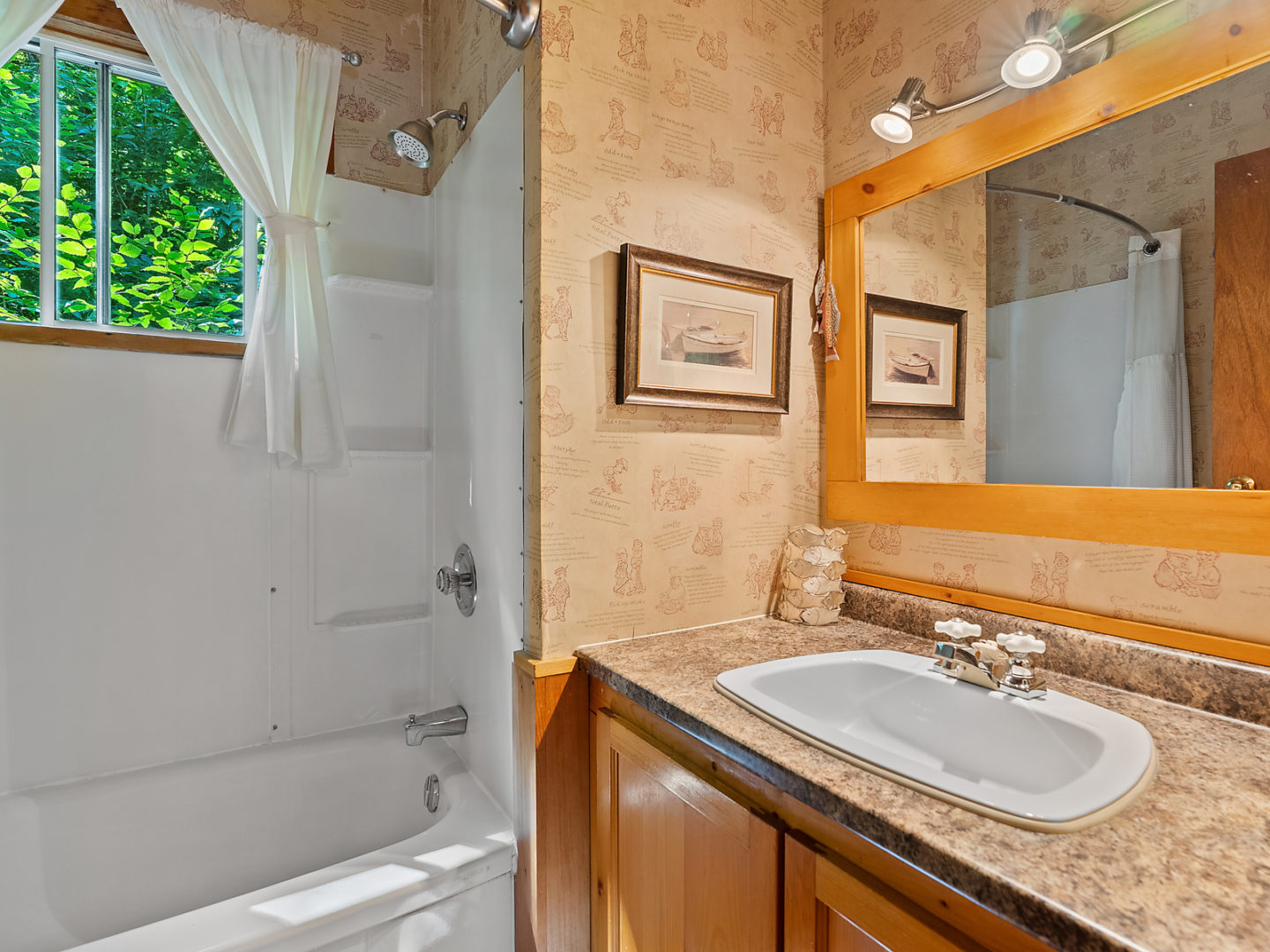 A small bathroom with a bathtub that has a shower head and a sink.