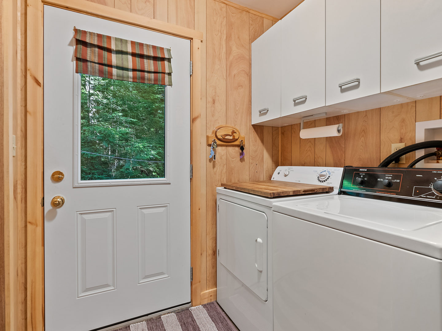 A small entrance area with a washing machine and a dryer off to the side.