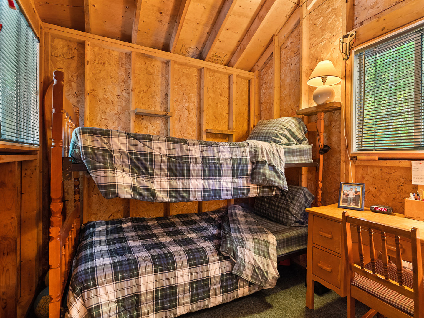 A set of bunkbeds inside a small wooden bunkie space.