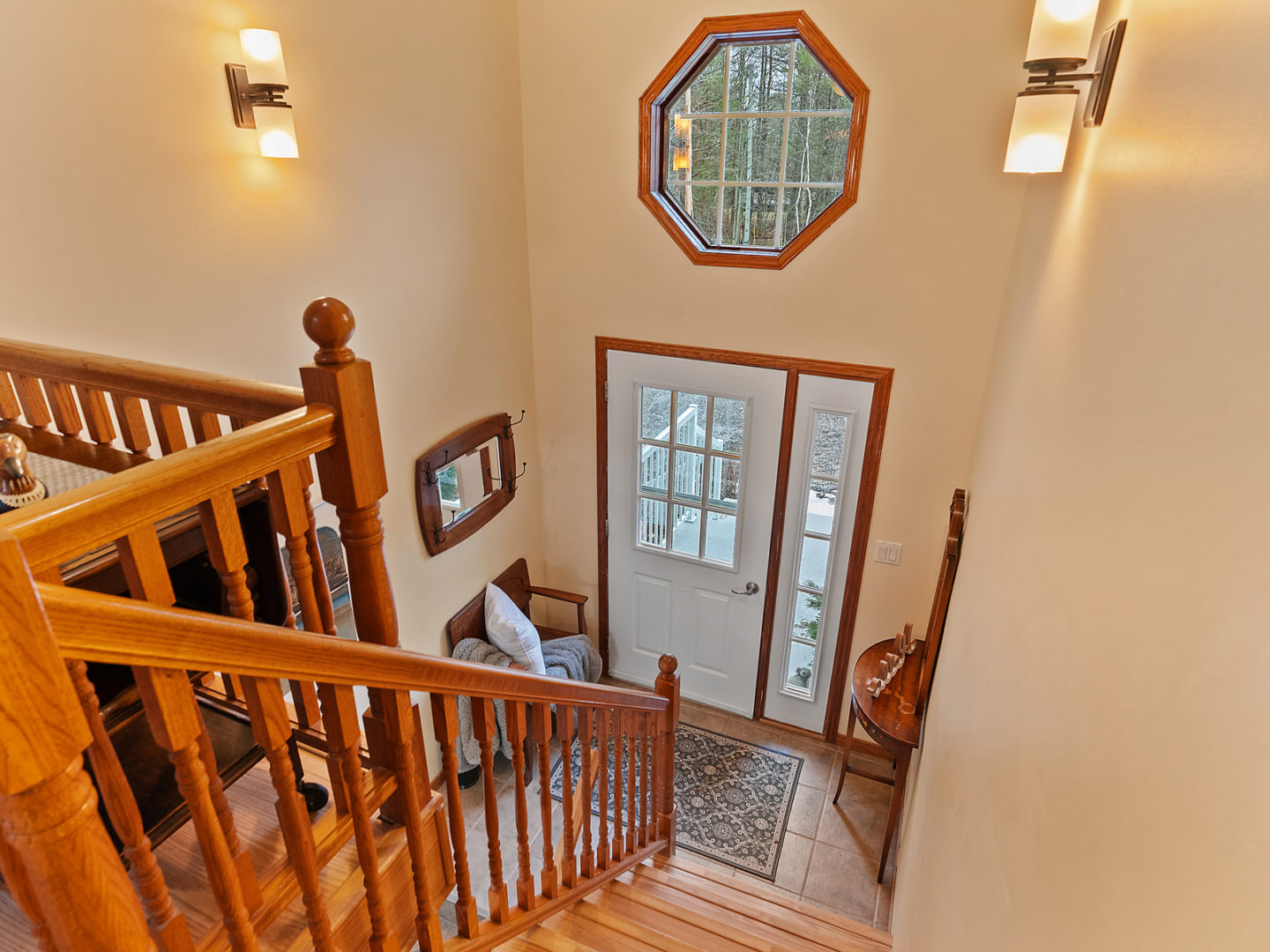 A small front entrance of a house at the bottom of a staircase.