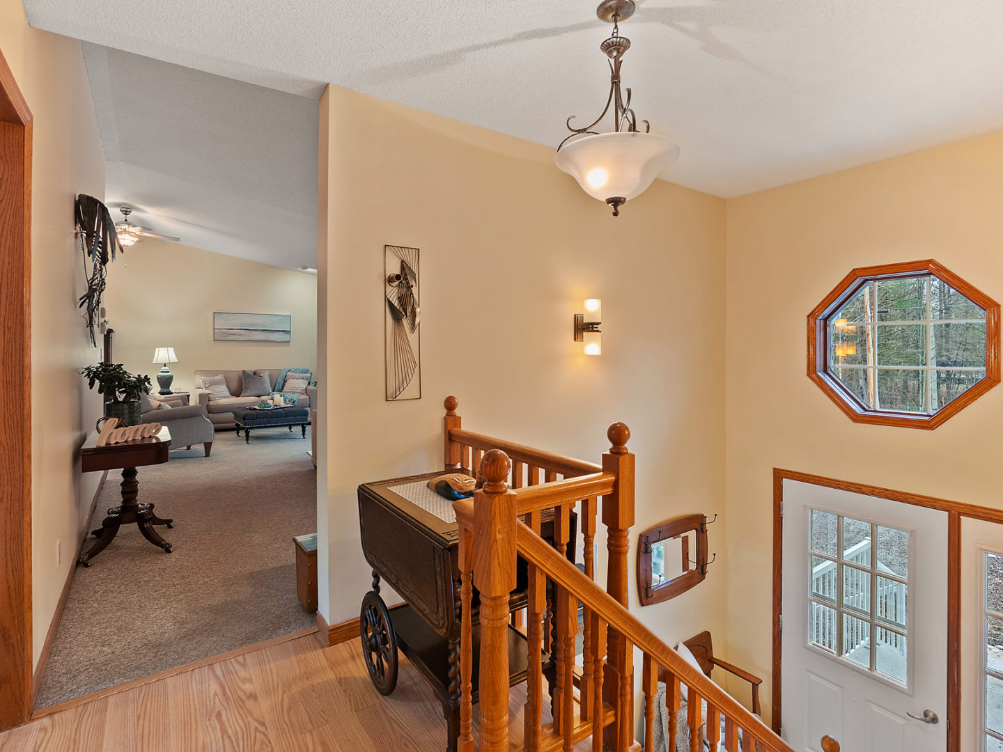 The top of a staircase, looking into a large living area.