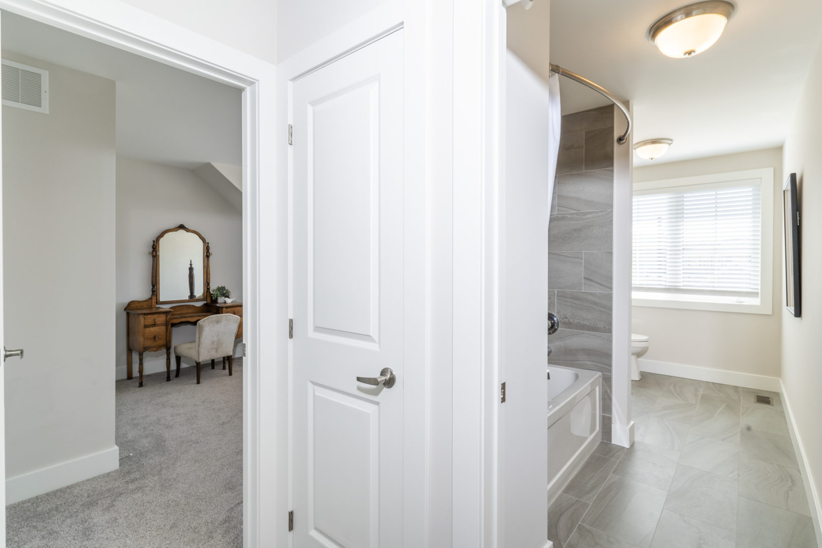 The end of a hallway with two doors, one looking into a bathroom and one looking into a bedroom.