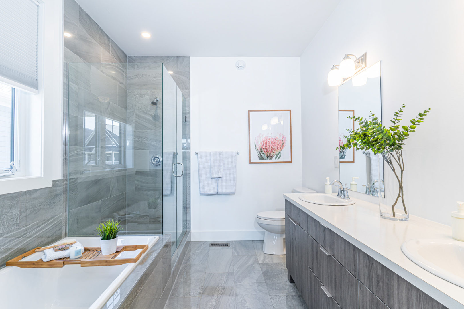 A big bathroom with a toilet, double sinks, a walk-in shower, and a bathtub.