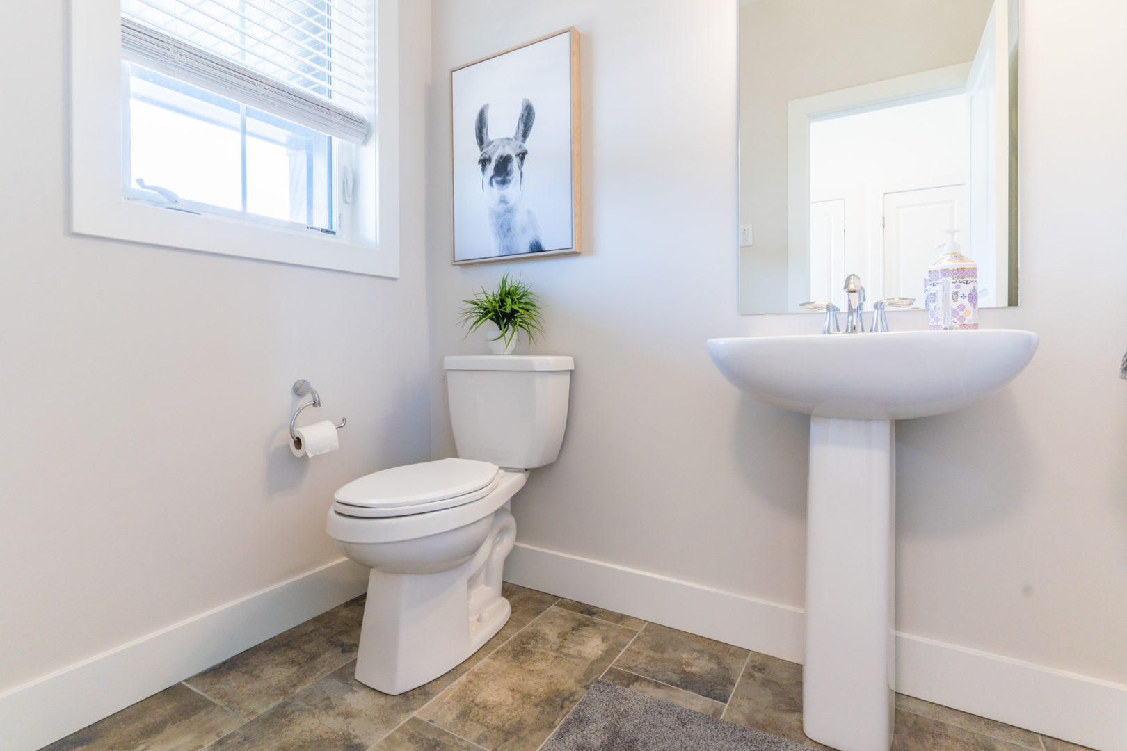 A small, bright bathroom with a toilet and a sink.