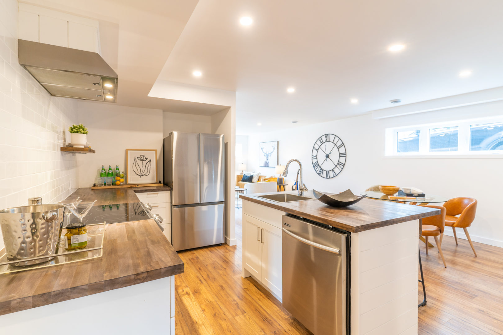 A basement kitchen area with a small island, a sink, and updated appliances.