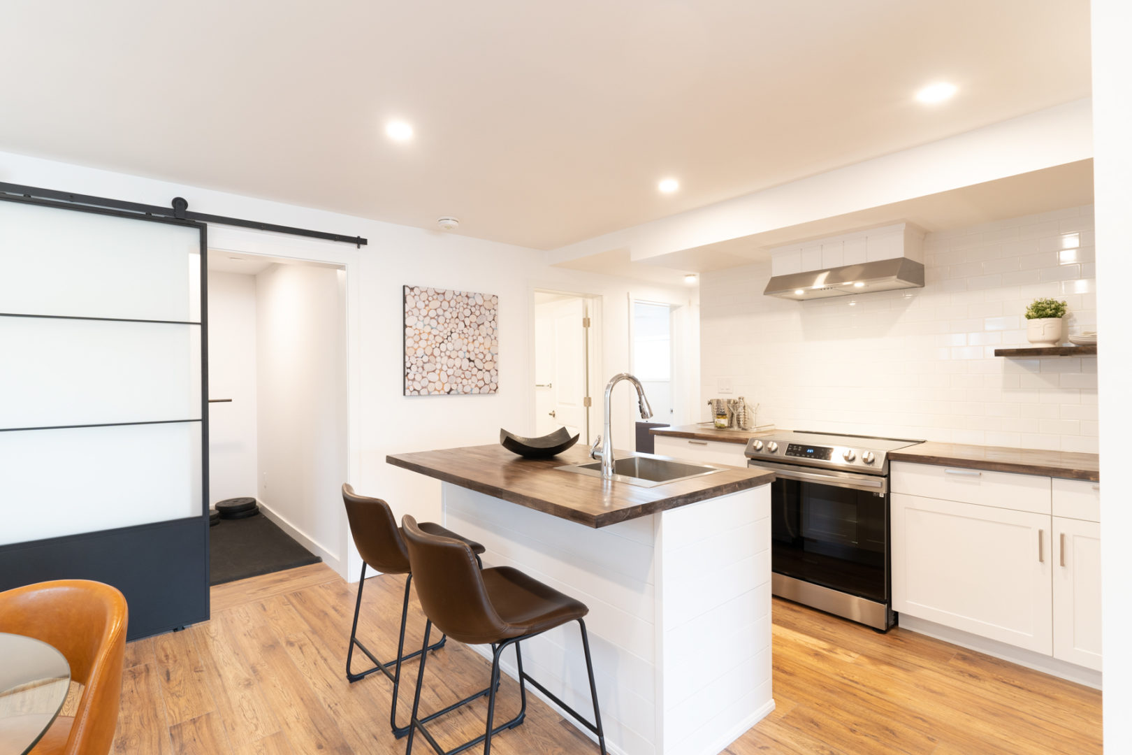 A spacious basement kitchen area with a small island and updated appliances.