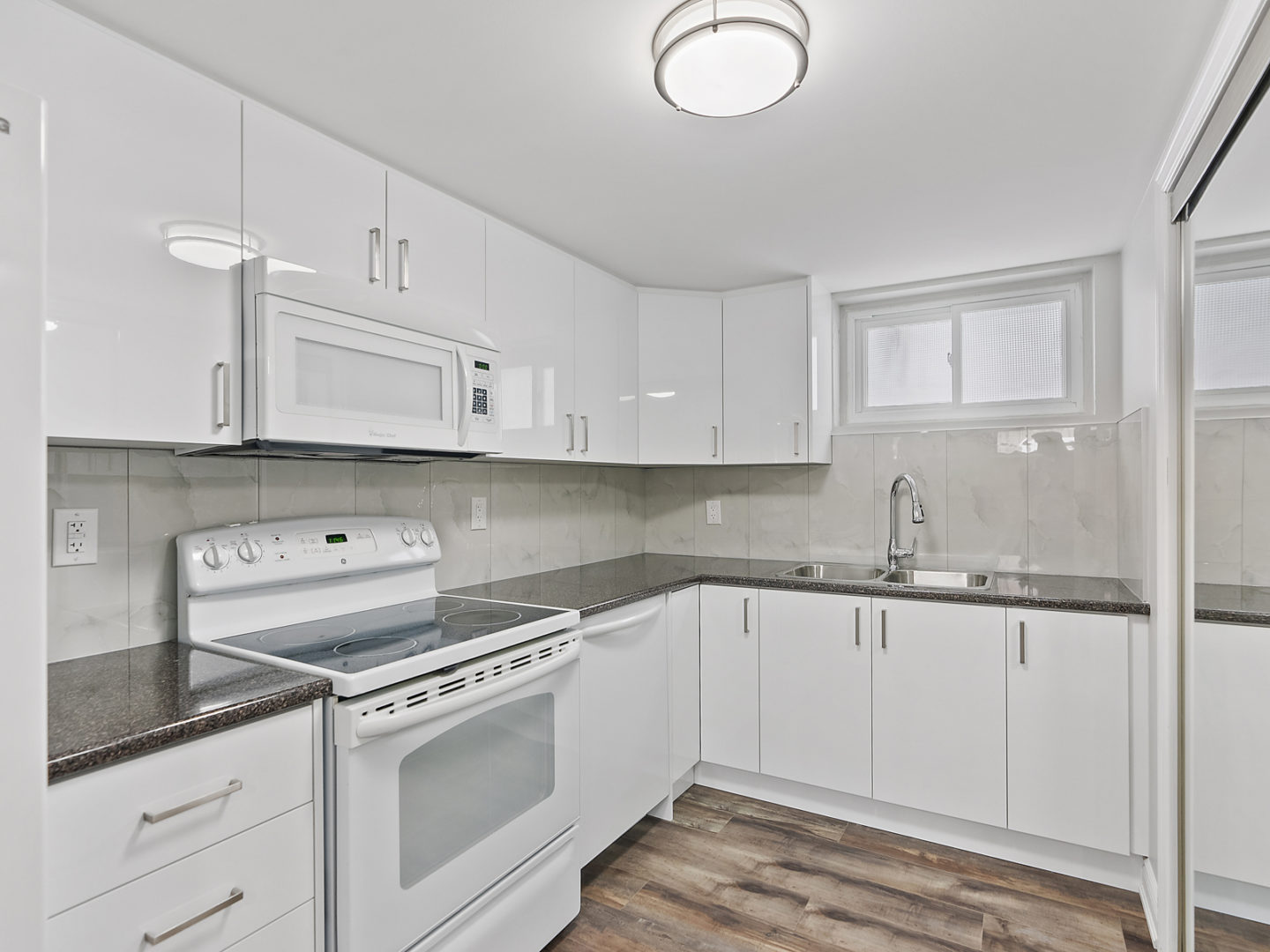 A small downstairs kitchen area with plenty of cupboard space, an oven, and lots of counter space.