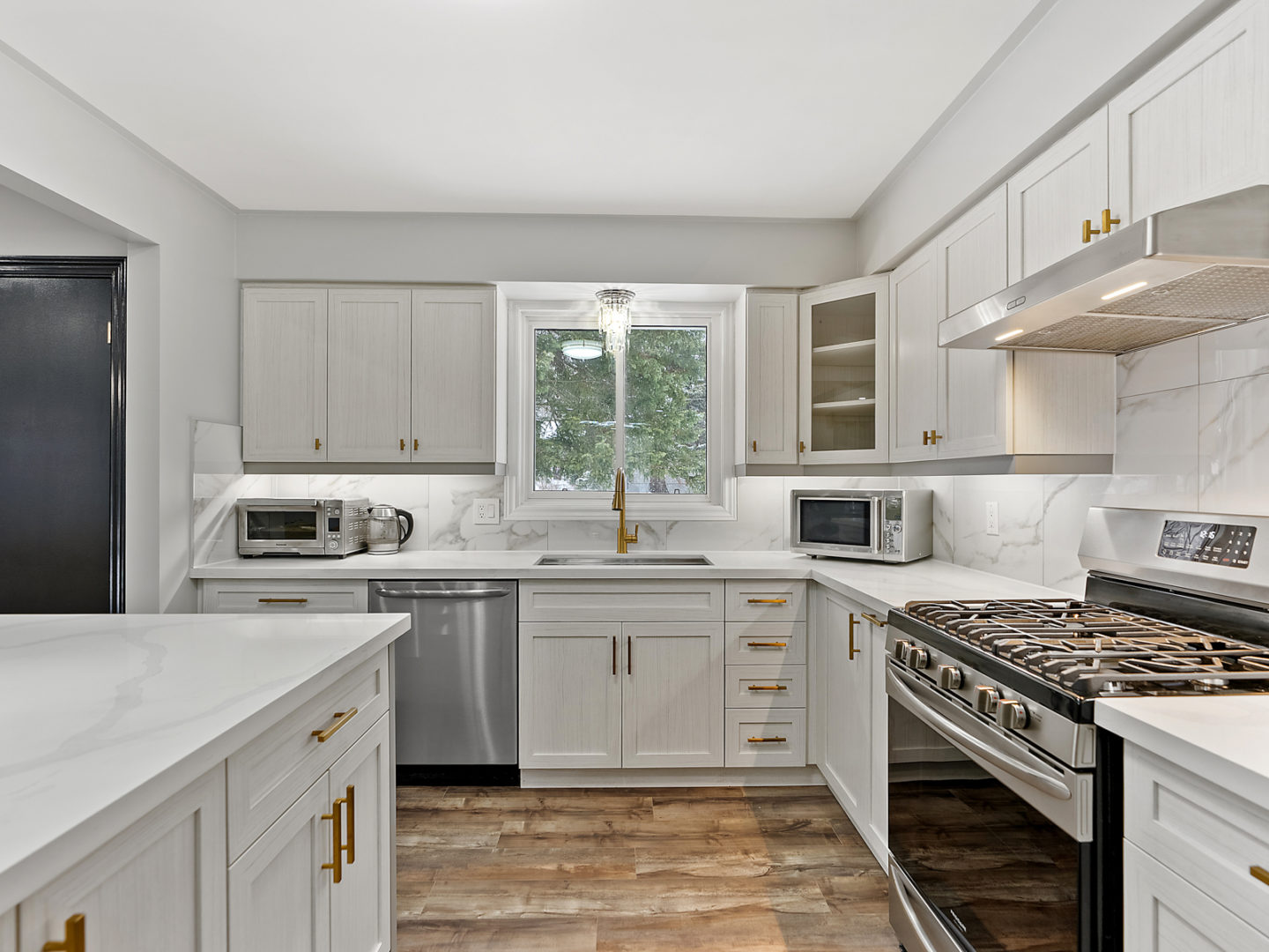 A bright, newly renovated kitchen with an island, lots of counter space, and updated appliances.