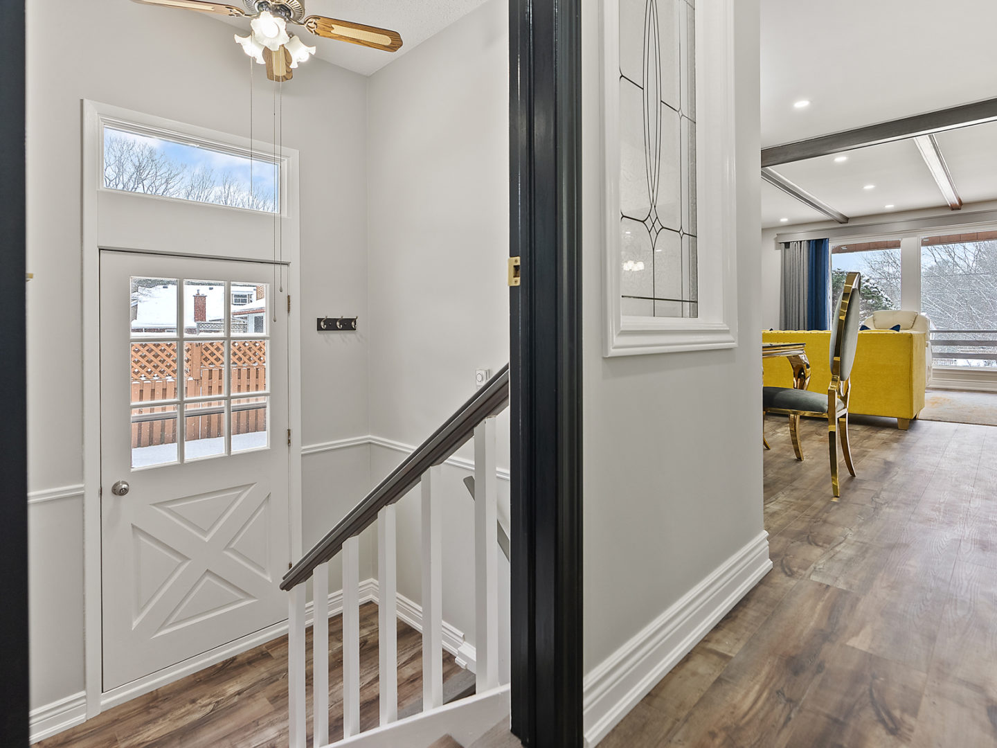 A small set of stairs lead down to the side entrance of a house.
